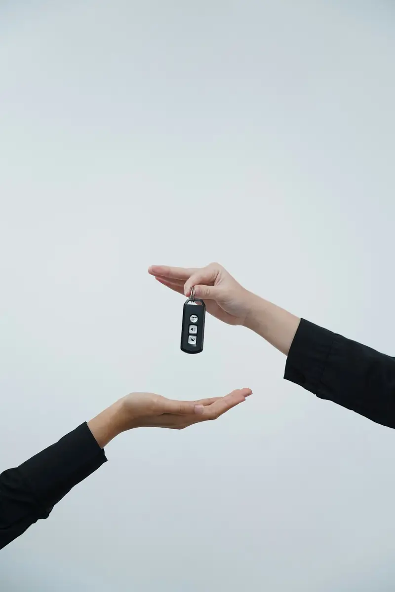 Car keys being handed from one person to another